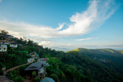 Scenic view of town by mountain against sky