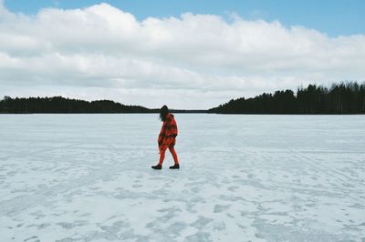 Full length rear view of man standing on snow covered landscape