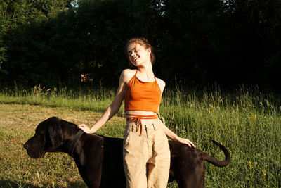 Portrait of young woman standing on grassy field