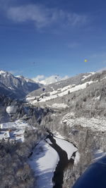 Scenic view of snowcapped mountains against blue sky