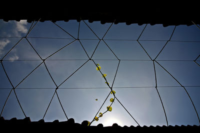 Low angle view of silhouette fence against sky