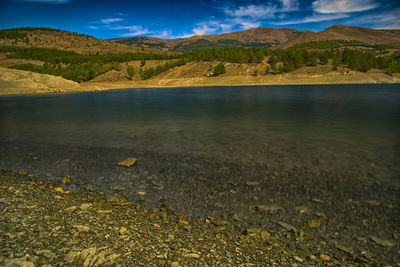 Scenic view of lake and mountains against sky