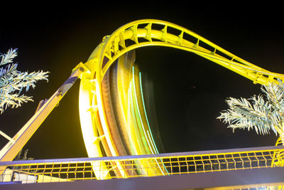 Low angle view of light trails against sky at night