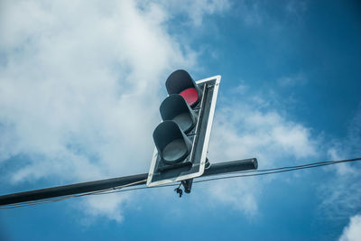 Low angle view of road signal against sky