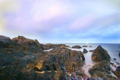 Rocks on beach against sky