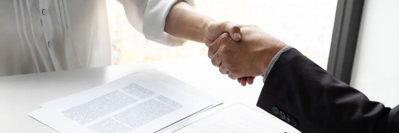 Midsection of couple holding hands on table