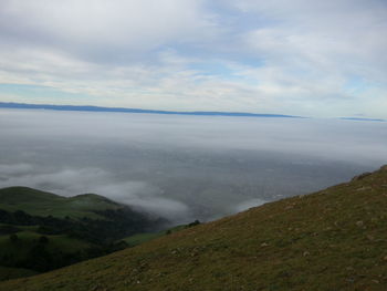 Scenic view of mountains against cloudy sky