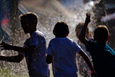 Rear view of people standing in water