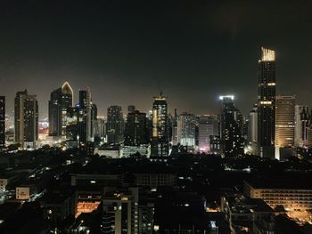 Illuminated buildings in city against sky at night