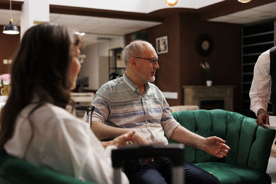 Side view of man sitting on chair