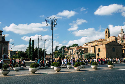 People on street against buildings in city