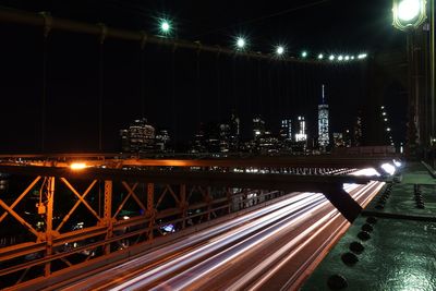 Illuminated light trails on road against sky at night