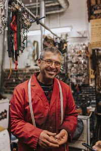 Portrait of happy male locksmith wearing eyeglasses in workshop