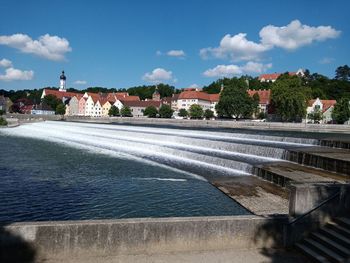 Fountain in city against sky