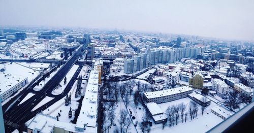 Snow covered cityscape against sky