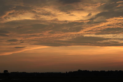 Scenic view of silhouette landscape against dramatic sky during sunset