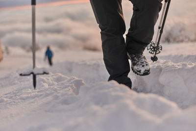 Low section of people standing on snow covered land