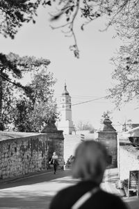 Rear view of man and woman tower against sky in city