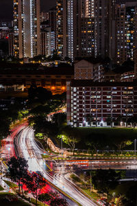 High angle view of illuminated street amidst buildings at night