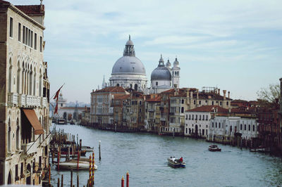 Boats in canal amidst buildings in city