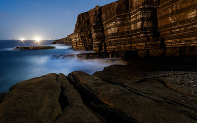 Rock formations in sea against sky