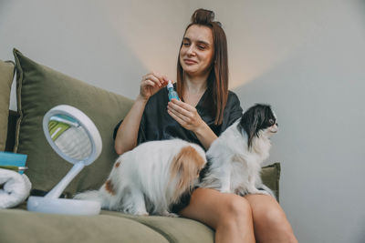 Portrait of young woman with dog at home