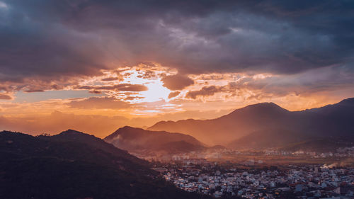 Scenic view of mountains against dramatic sky during sunset