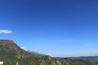 Scenic view of mountains against blue sky