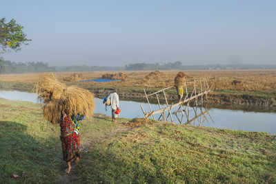 Rear view of woman standing on field against clear sky