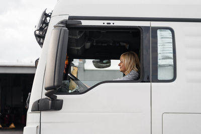 Low angle view of woman standing in car