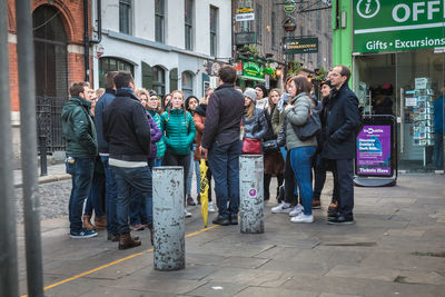 People walking on footpath in city