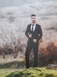 Portrait of young man standing on field