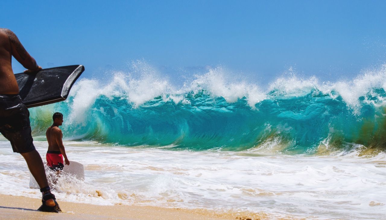 lifestyles, leisure activity, sea, water, beach, motion, men, wave, surf, vacations, full length, shore, sky, horizon over water, holding, standing, sand, scenics