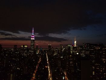 Illuminated cityscape against sky at night