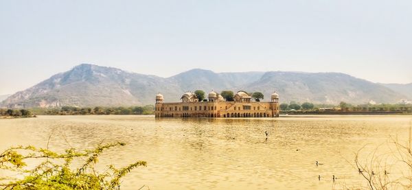 Scenic view of lake and mountains against clear sky