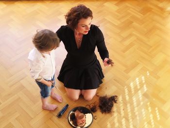 High angle view of women sitting on hardwood floor