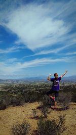 Rear view of woman practicing yoga at mountain against sky