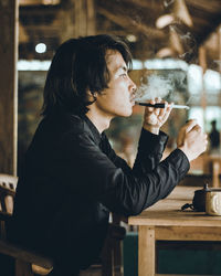 Side view of a man drinking glass