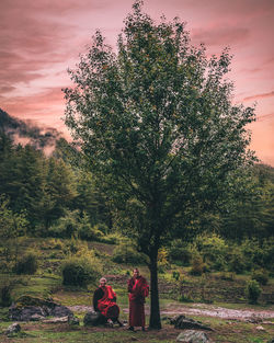 Rear view of people walking on tree against sky