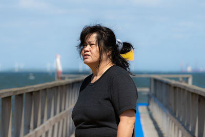 Portrait of woman standing against sea against sky