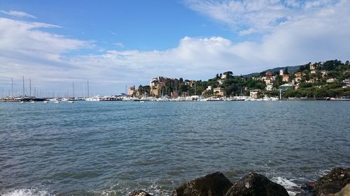 Scenic view of sea by town against sky