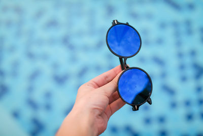 Close-up of hand holding blue glass