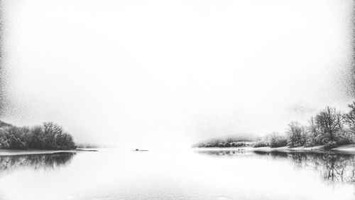Scenic view of lake against sky during winter