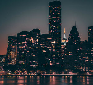 Illuminated buildings in city against sky at night