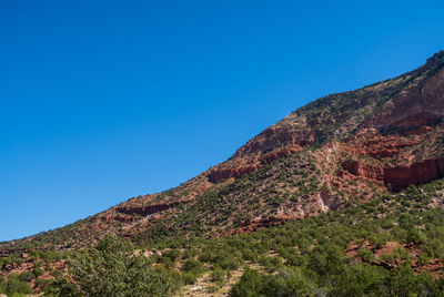 Low angle view of mountain against clear blue sky