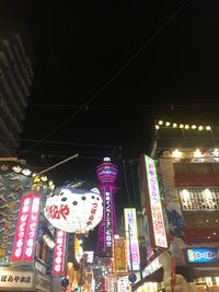 Low angle view of illuminated lanterns hanging by building at night