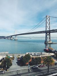 Low angle view of bay bridge over san francisco bay against sky