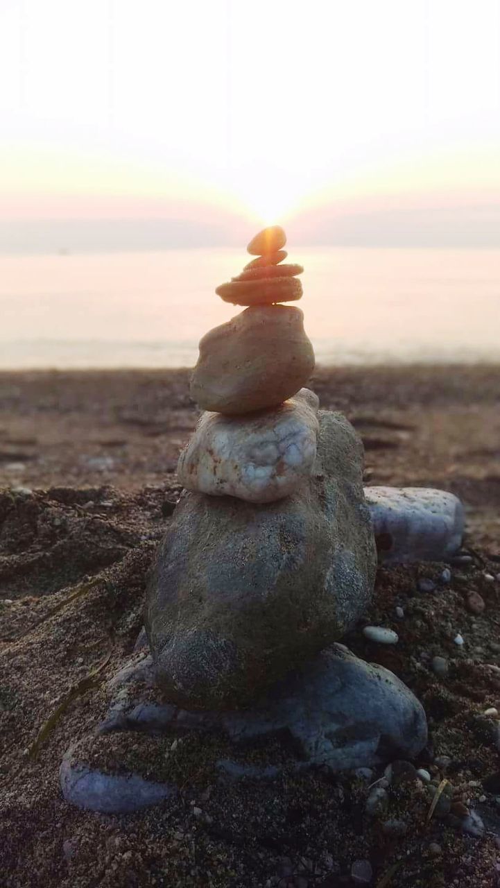 STONE STACK ON SAND AT BEACH AGAINST SKY