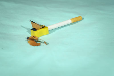 Close-up of yellow cigarette on table