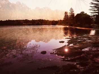 Scenic view of lake against sky at sunset